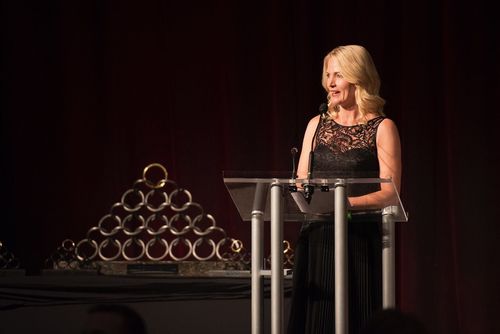 Linda on stage at a Gala, talking behind a podium