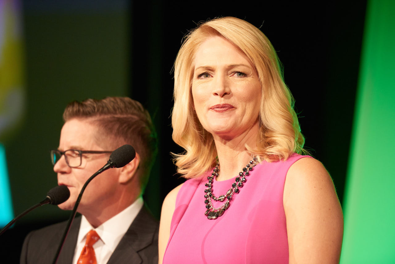 Linda on stage at a Gala, talking behind a podium