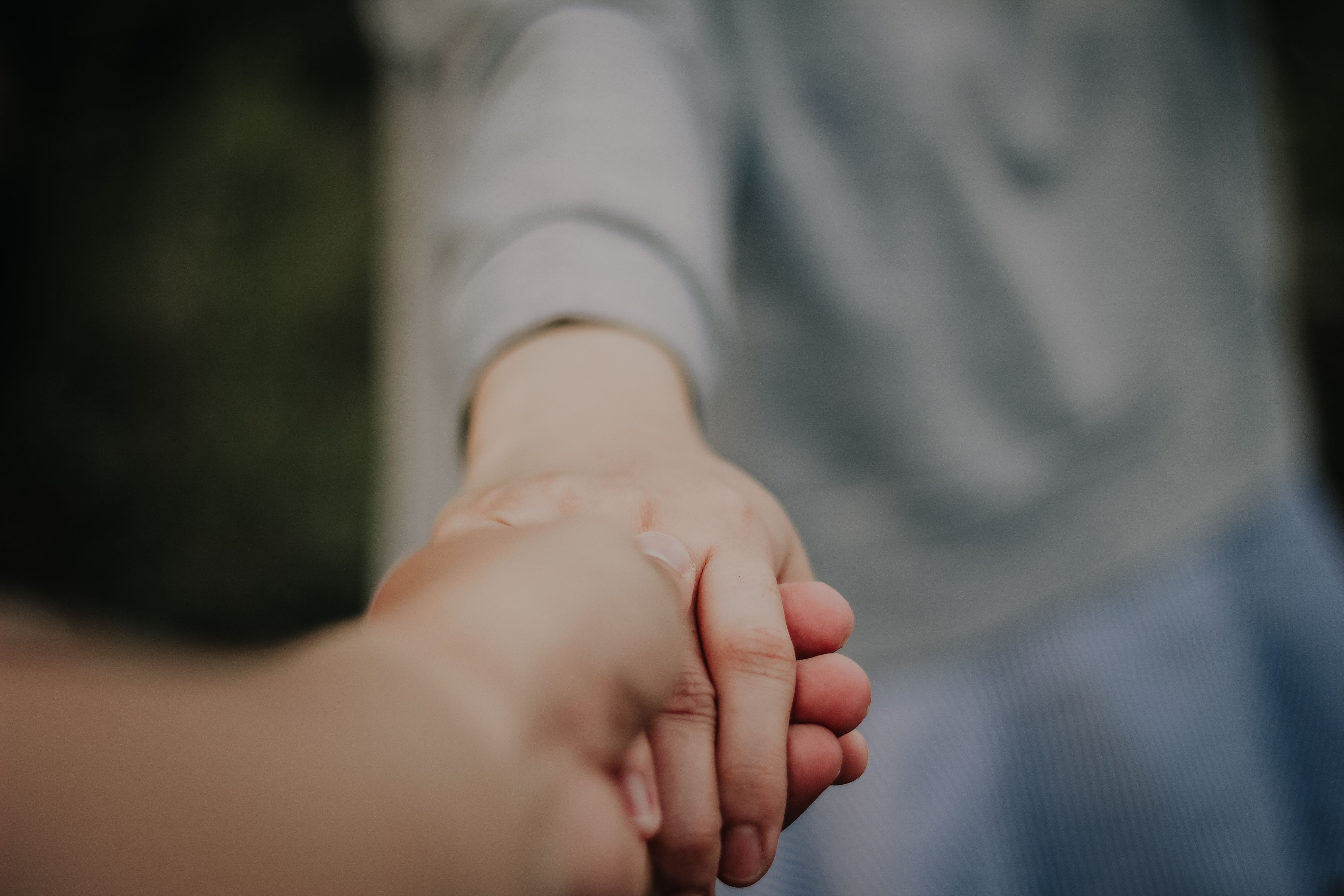 Two people holding hands in a gesture of support