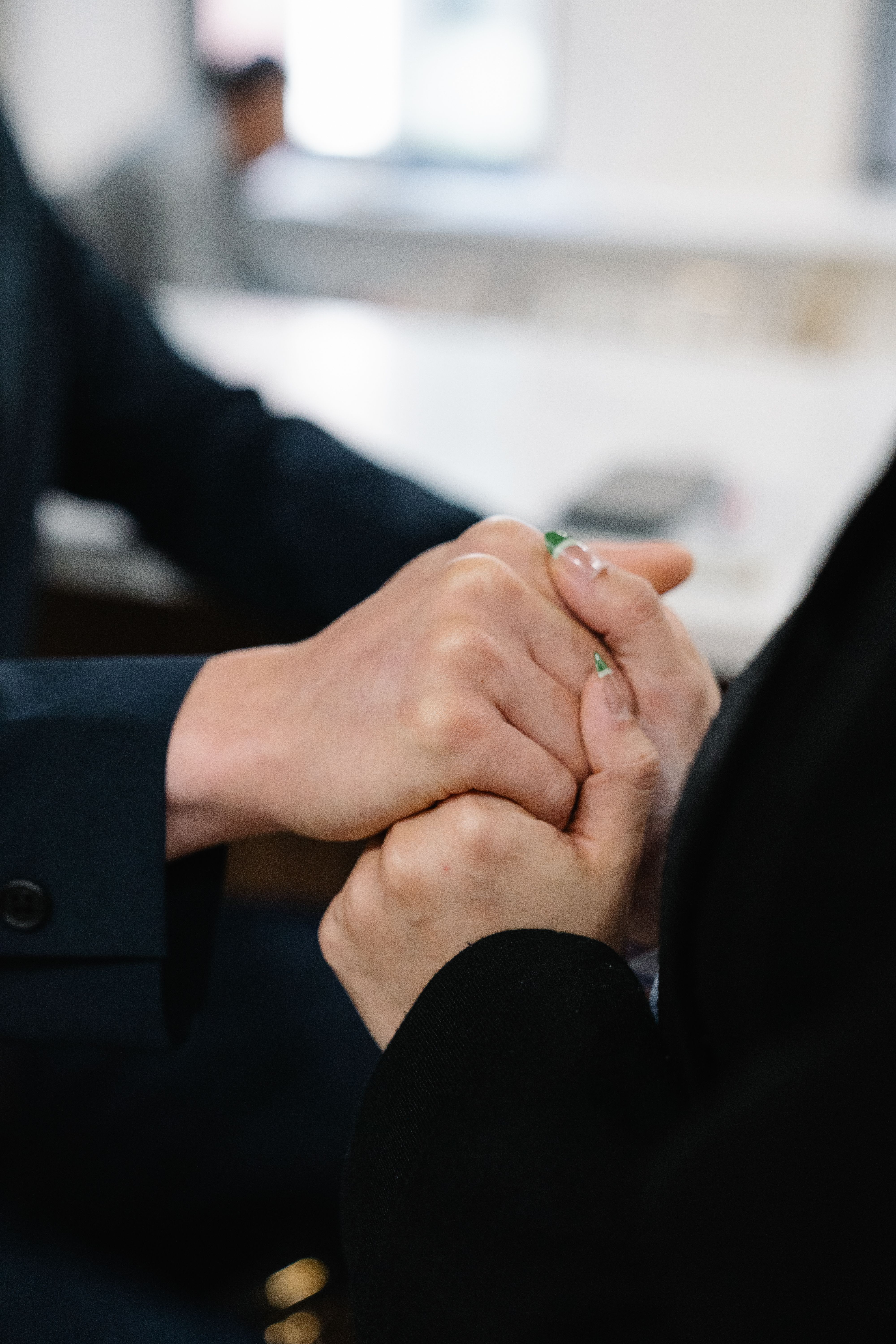 Close-up of two people holding hands in support