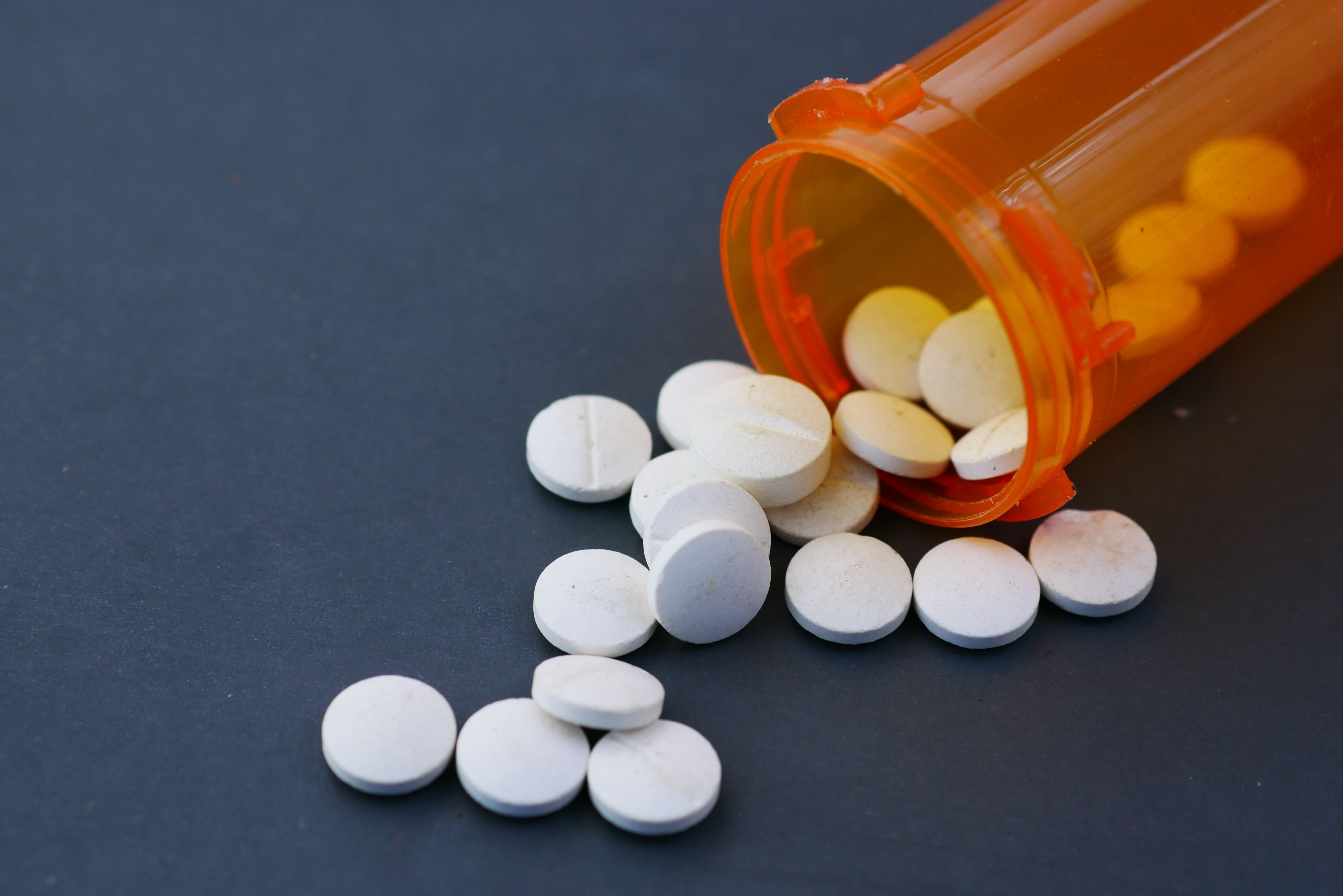 Prescription pills spilled from an orange bottle