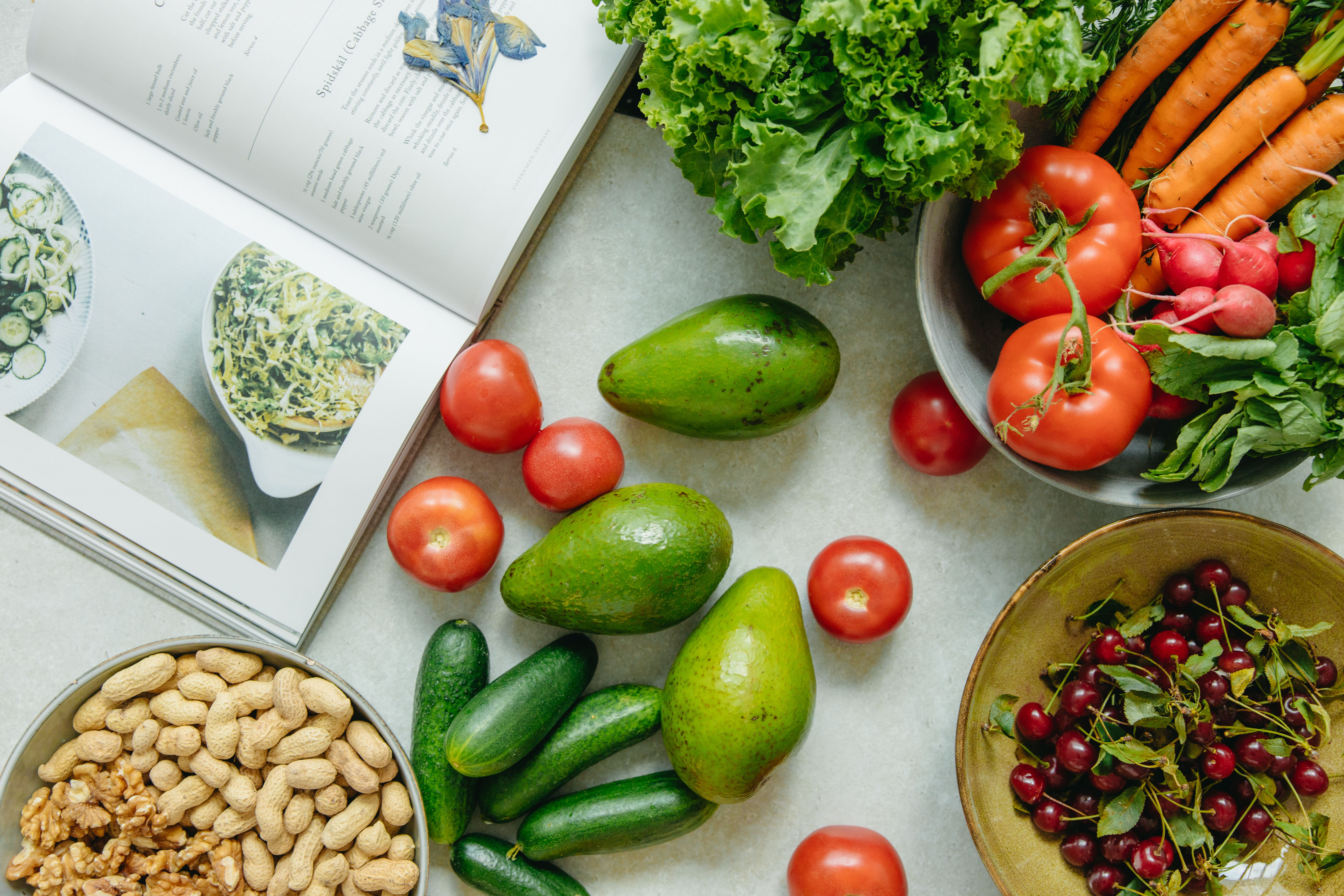 Assortment of healthy foods with a cookbook on a table