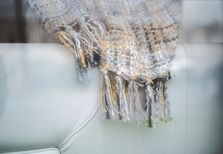 Close-up of a textured throw blanket draped on a light-colored sofa, showcasing cozy home decor.