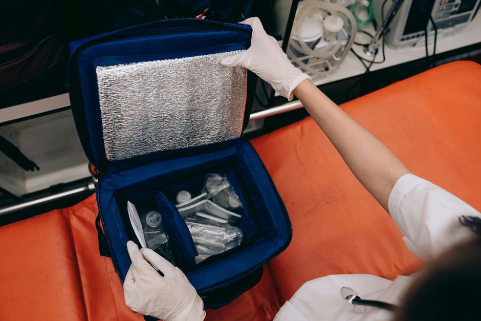 Paramedic utilizing an intubation kit with medical tools in an emergency setting.