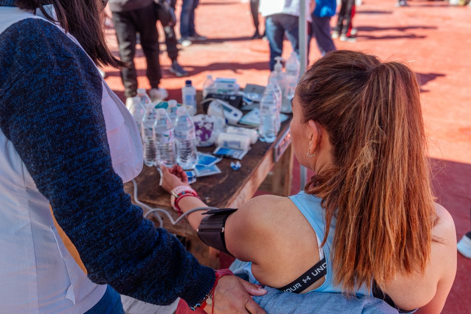 Woman in sportswear undergoing a health check outdoors during a sports event.