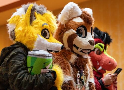 A group of fursuiters smiling at the camera