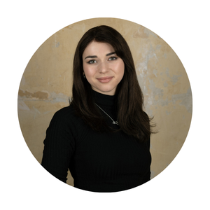 Portrait of a woman with long dark hair wearing a black top, shown in a circular profile photo.