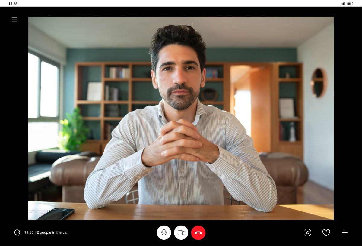 Business executive on a video conference call, illustrating the kind of multi-participant meeting exploited in deepfake CEO fraud.