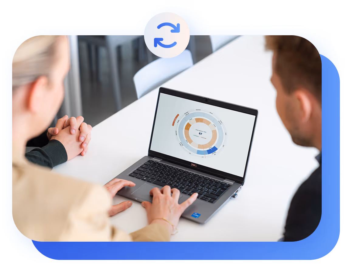 Two people viewing compliance task wheel on laptop screen