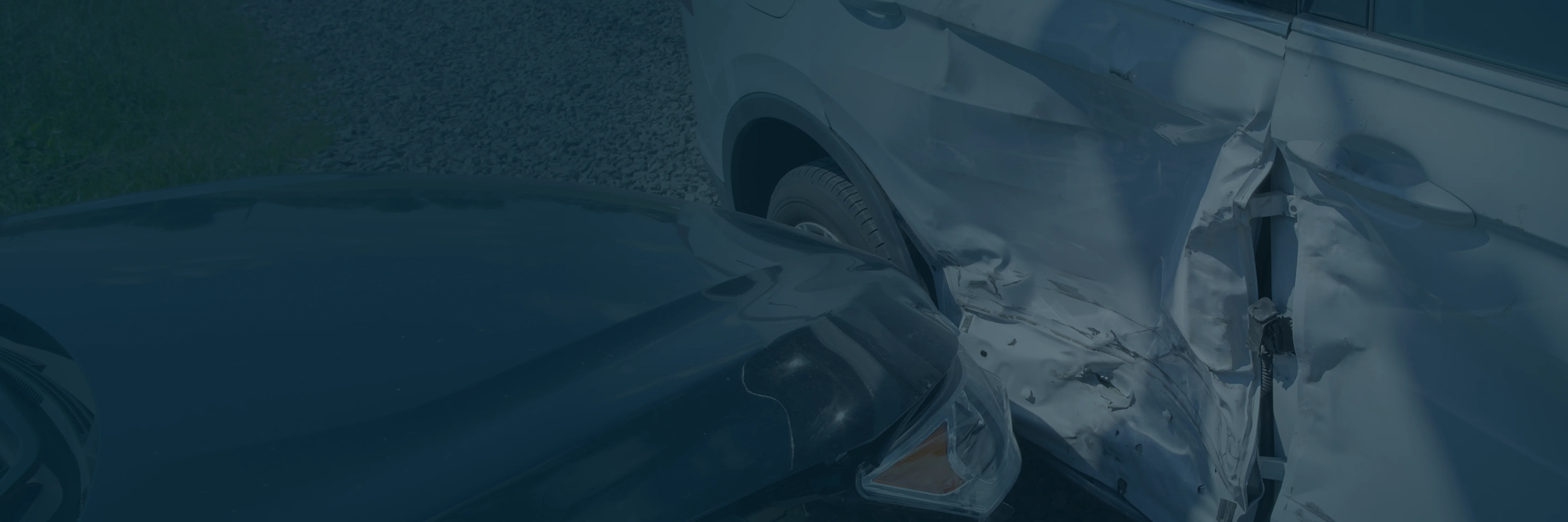 Two cars collided, showing heavy damage to the side door of a white car and the front of a dark-colored car.