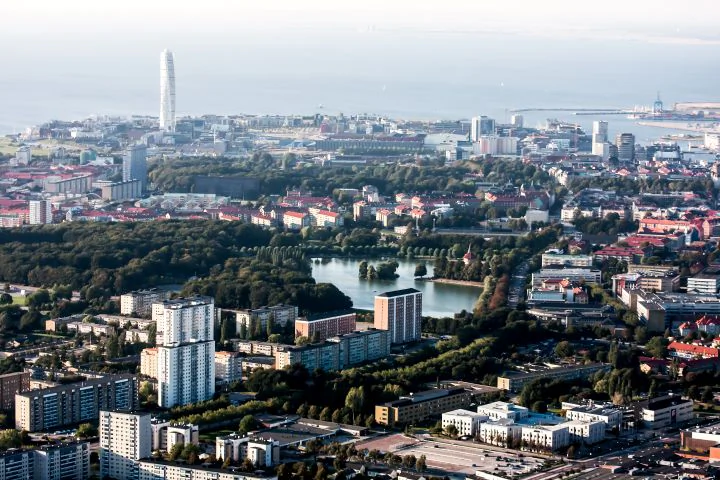 Flygvy över Malmö med Turning Torso, stadskvarter och Öresund i bakgrunden.