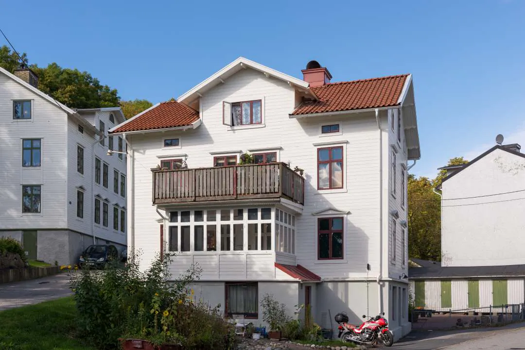 Villa med tegeltak och ljus fasad i Färjestaden nära kustnära bebyggelse.