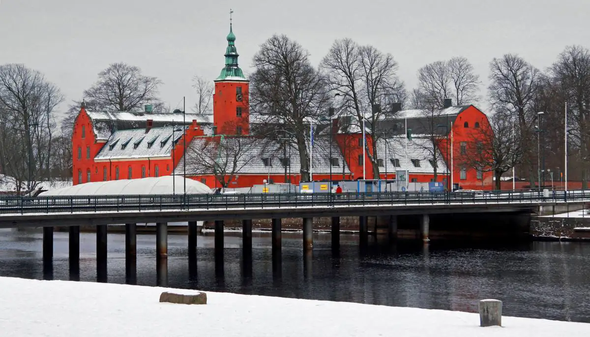 Halmstads slott och Nissan i vintermiljö med snö längs vattnet.