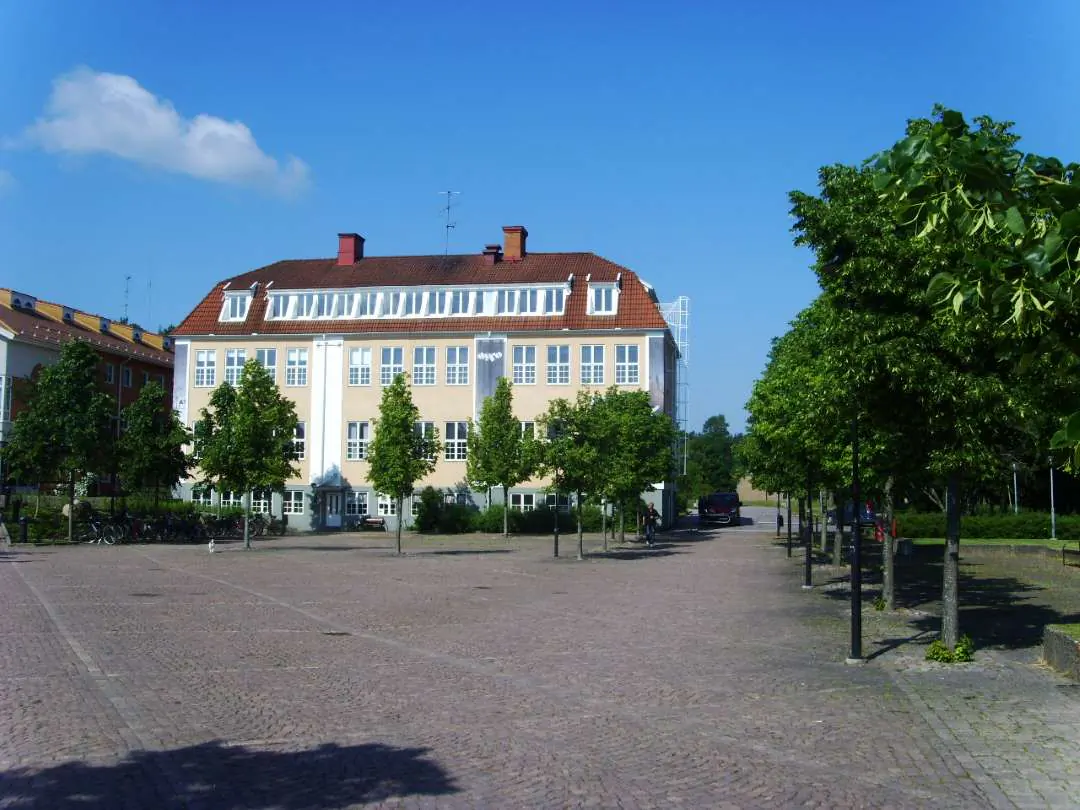 Ljus centrumbyggnad vid öppen torgyta i Hultsfred.