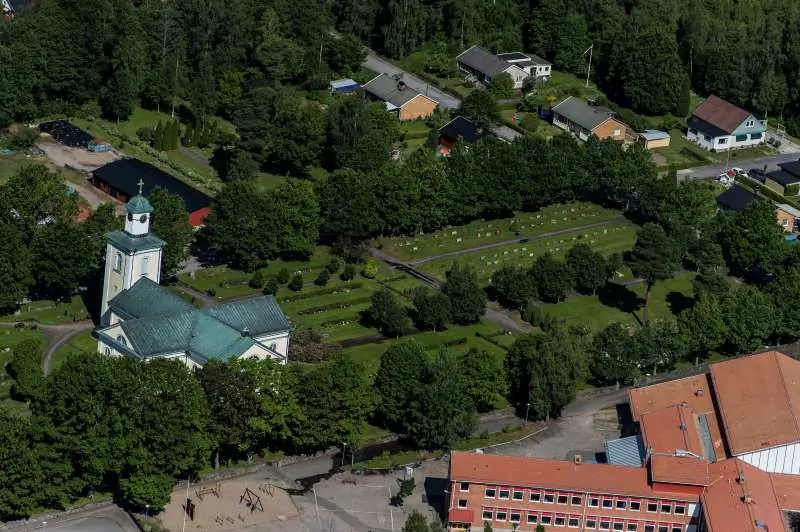 Flygvy över Hovmantorp med kyrka, villor och grönskande omgivningar.