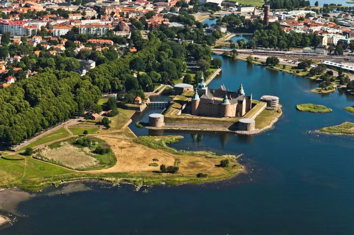 Flygvy över Kalmar slott vid vattnet med stad och kustlinje runtom.