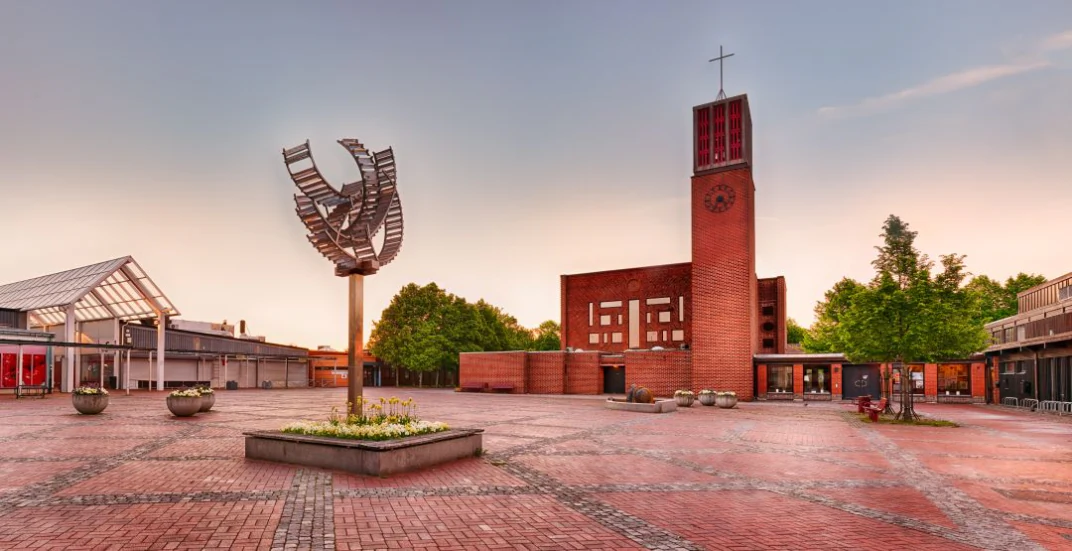 Torgmiljö i Lund med stadshus, skulptur och röda tegelfasader.