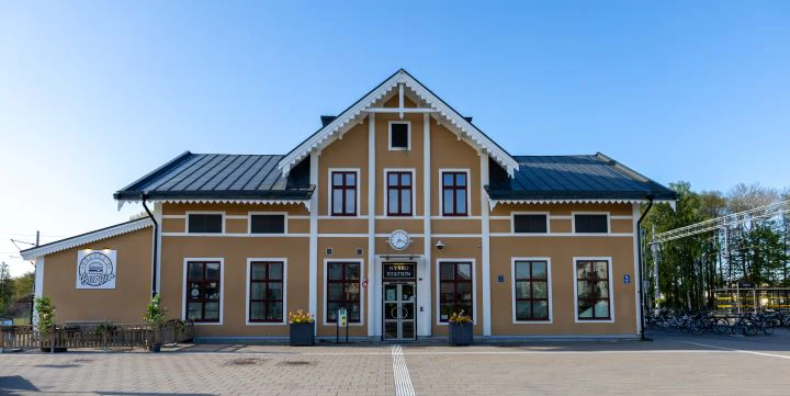 Stationshusliknande tegelbyggnad i Nybro med stora fönster och takkupor.