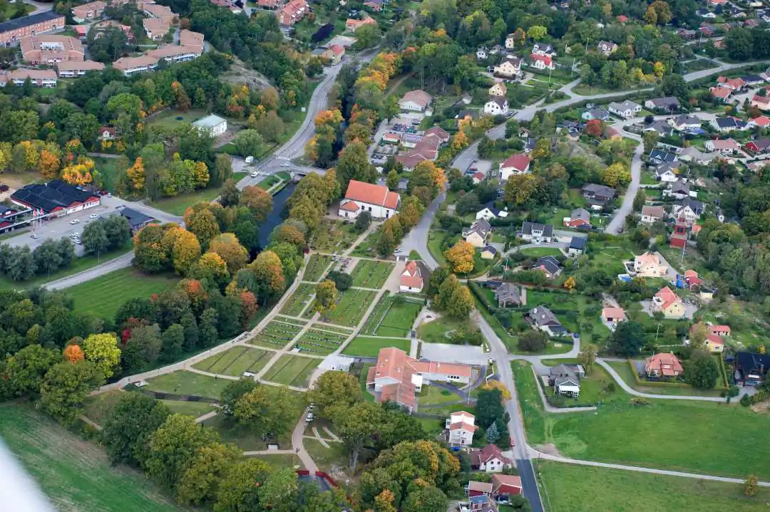 Flygvy över Nättraby med parkstråk, villor och gröna trädgårdar.