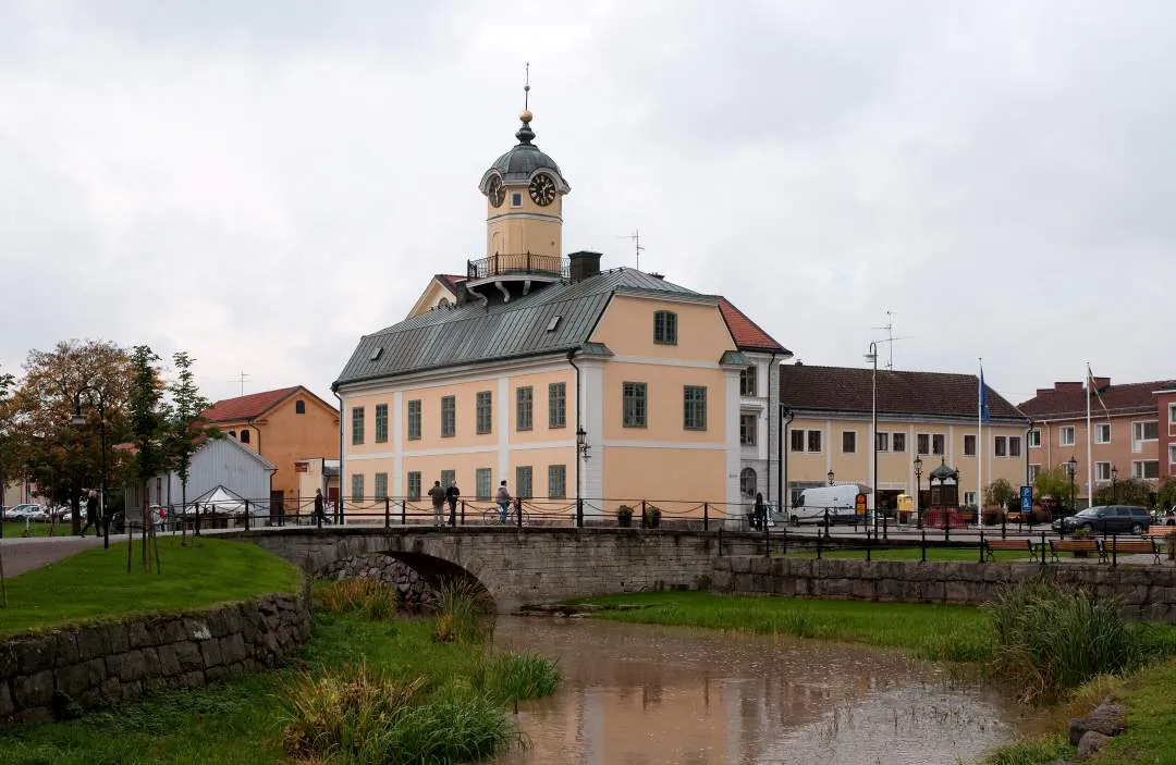 Bro och ljus byggnad vid vattnet i Söderköping.