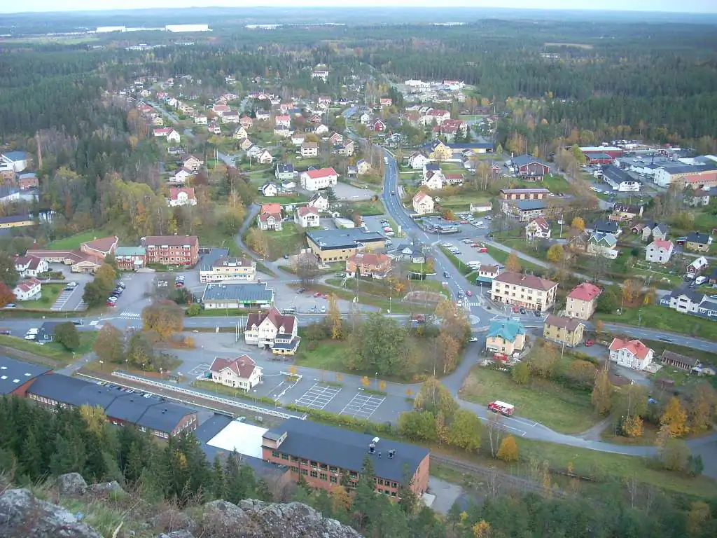 Flygvy över Tabergs tätort med villor, skog och gröna höjder.