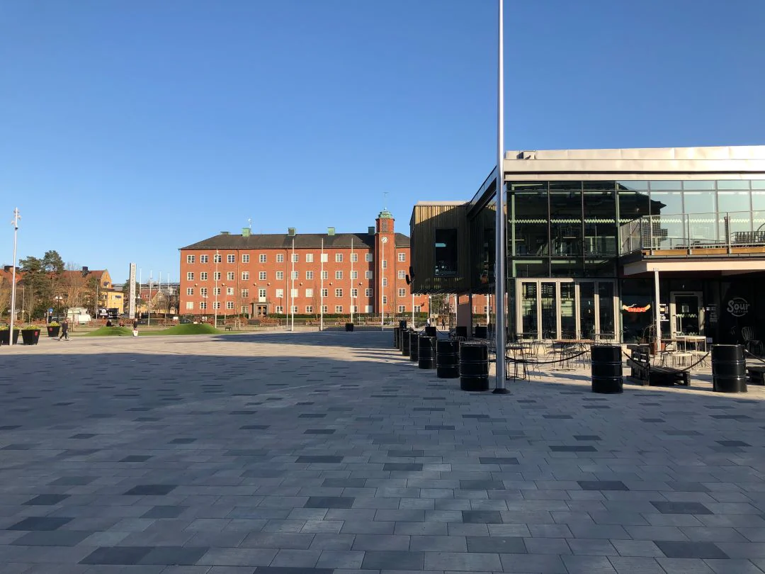 Öppet torg i Trollhättan med moderna byggnader och stenlagda ytor.