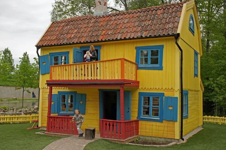 Färgstarkt trähus i Vimmerby med gul fasad, röda detaljer och veranda.