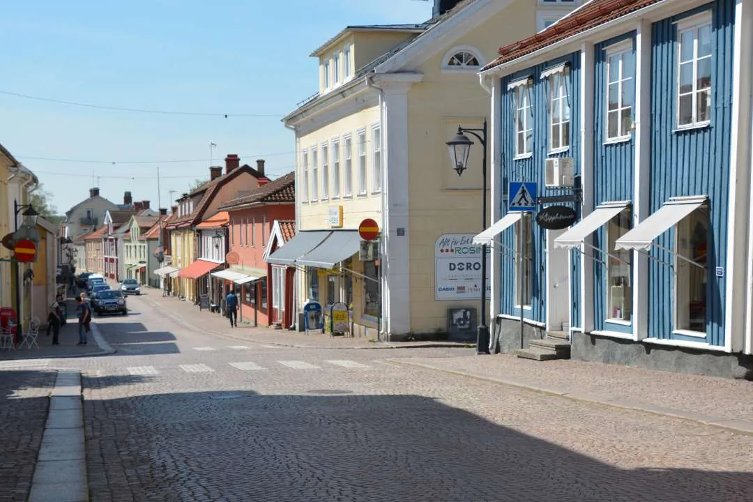 Gågata i Vimmerby med trähus, butiker och äldre småstadsmiljö.