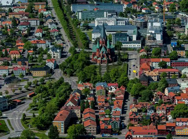 Flygvy över Västervik med stadskärna, kyrka, hamn och röda tak.