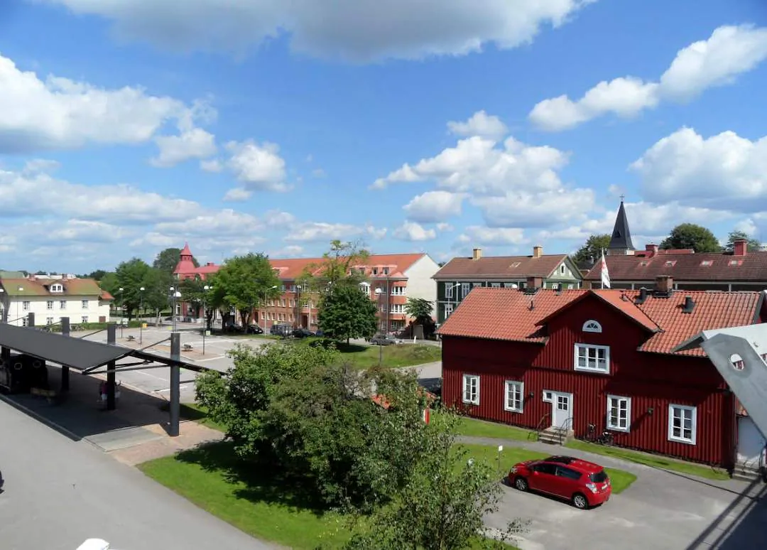 Vy över Älmhults centrum med röda tak, kyrktorn och småstadskvarter.