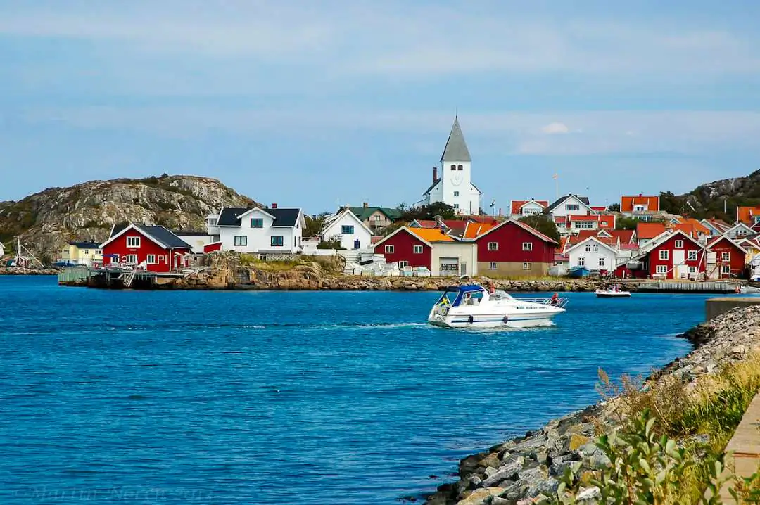Skärgårdsvik på Tjörn med röda hus, klippor och stilla vatten.