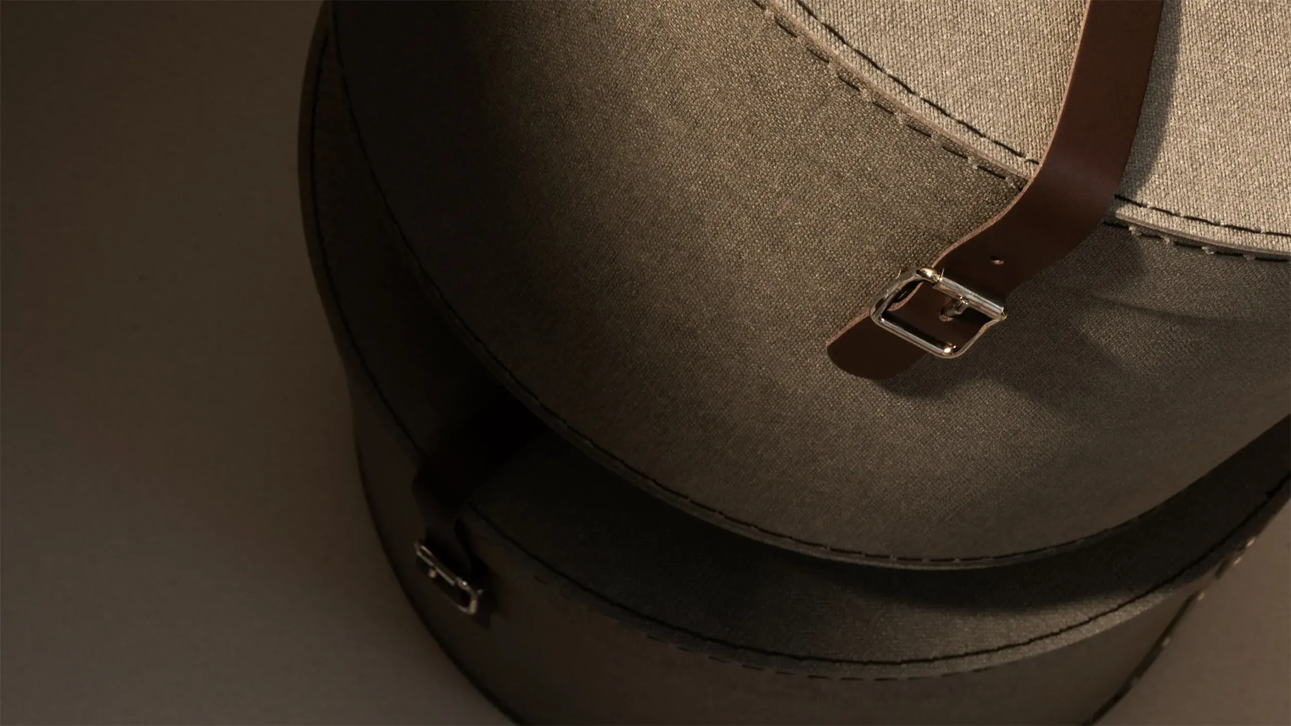 Close-up of Bigso round fabric storage boxes with leather straps and metal buckles, combining stylish design with practical home organization.