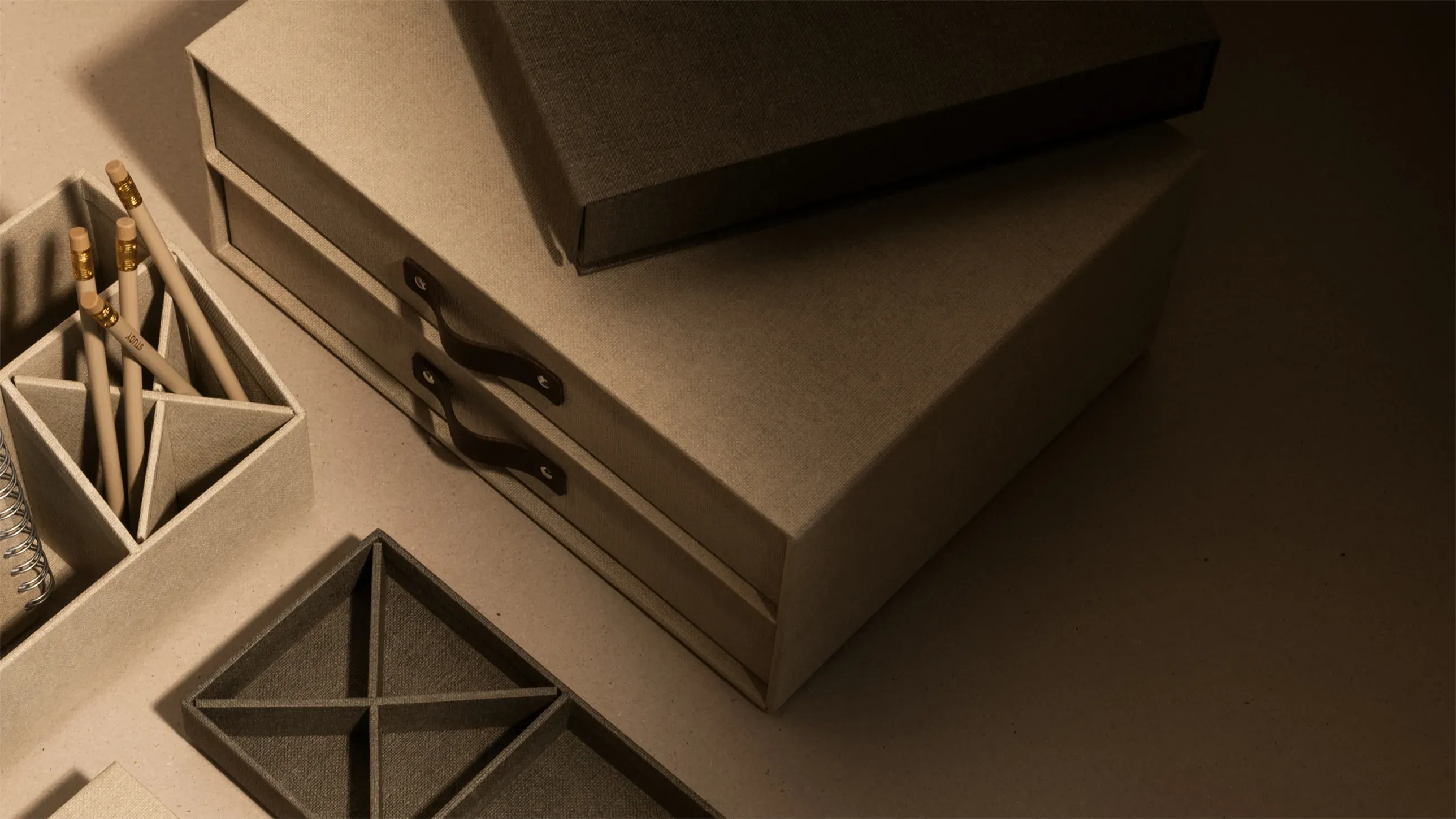 Bigso beige fabric desk organizers with compartment trays, pencil holders, and two-drawer storage boxes featuring leather pull handles for stylish home office organization.