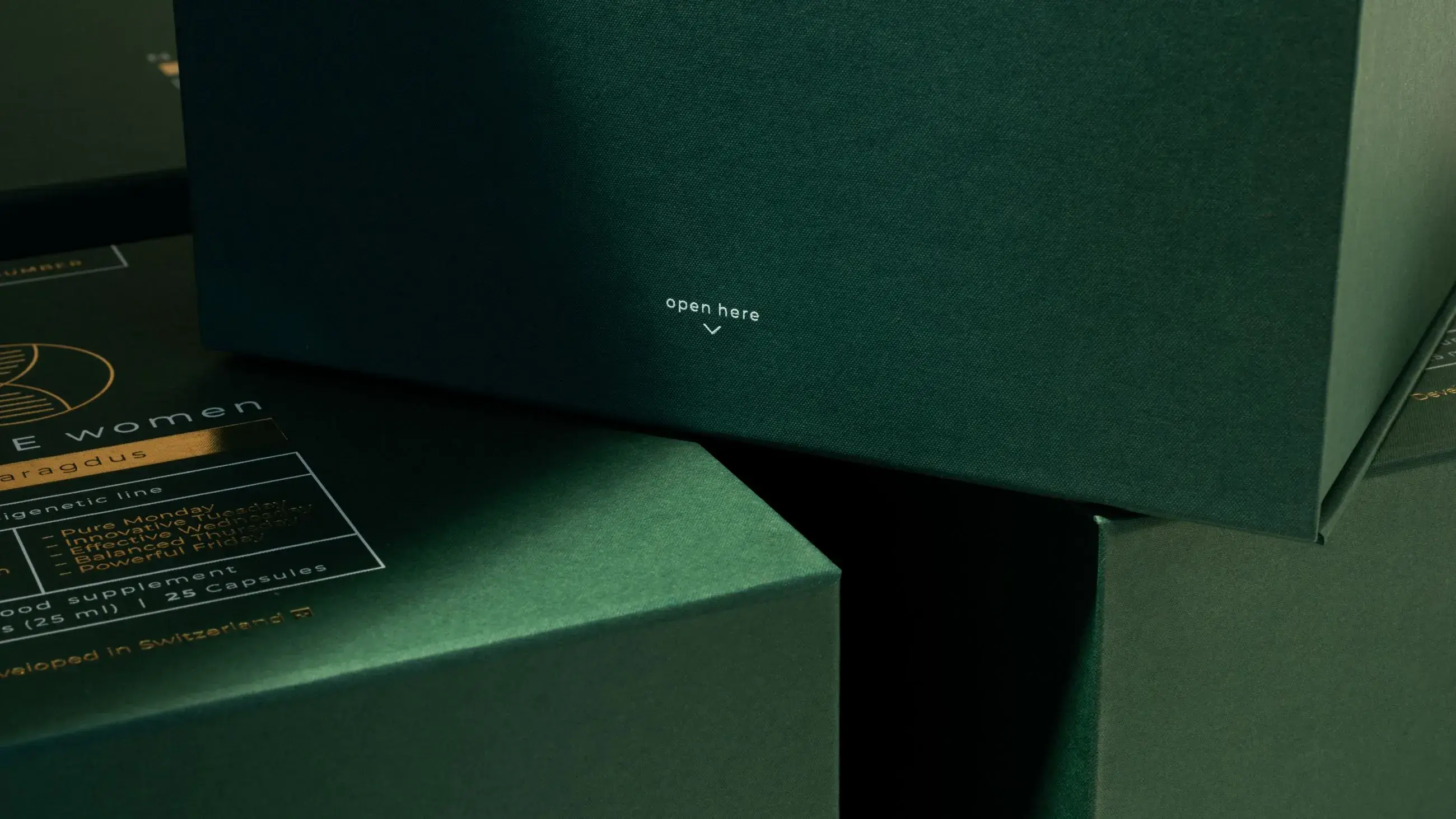 Close-up of premium dark green NoAGE Women Smaragdus packaging case manufactured by Bigso, showing gold detailing and 'open here' label for luxury supplement presentation.