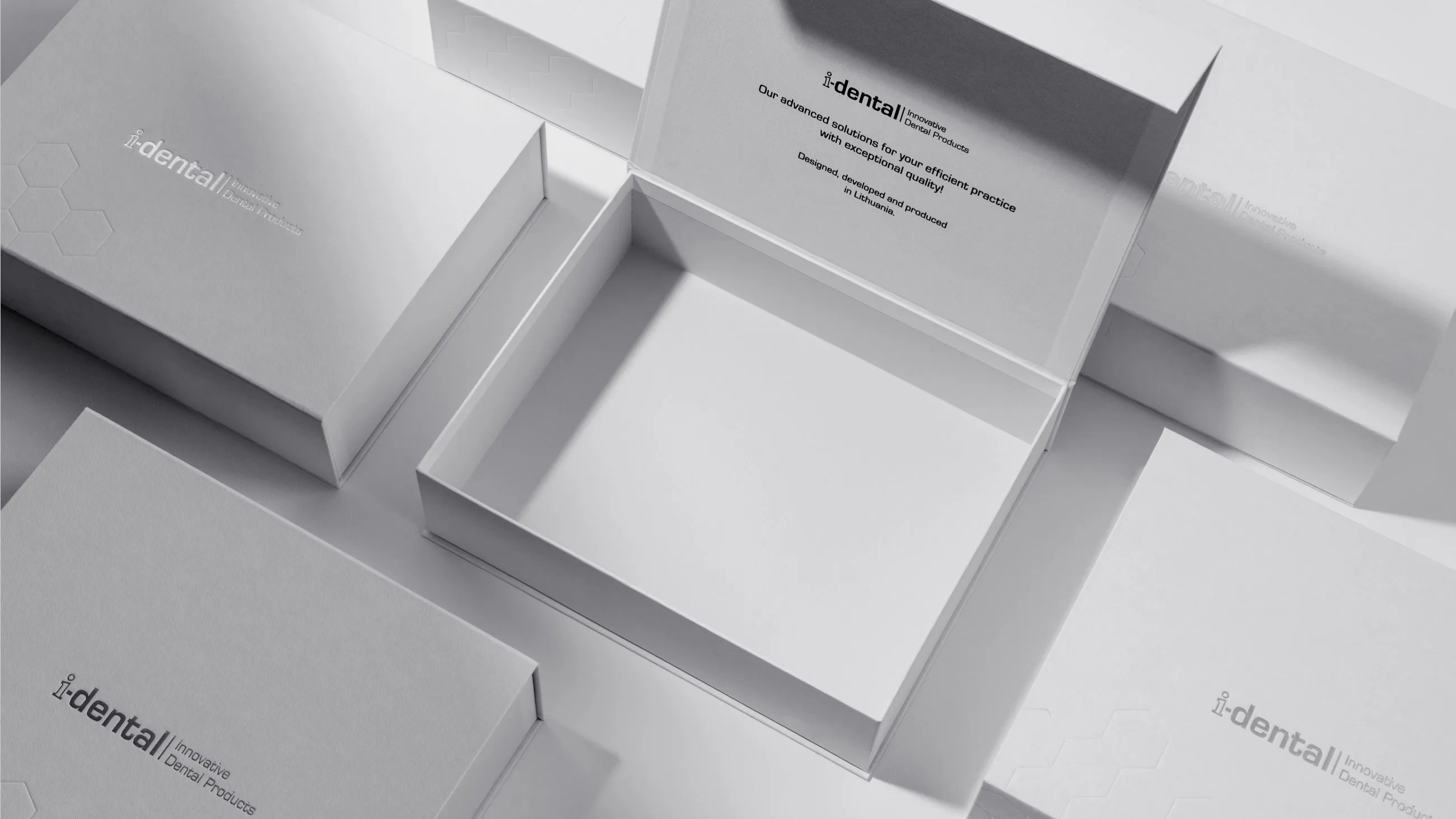 Open i-dental premium packaging cases manufactured by Bigso, showcasing elegant white design with embossed hexagon pattern and branded interior printing for dental products.