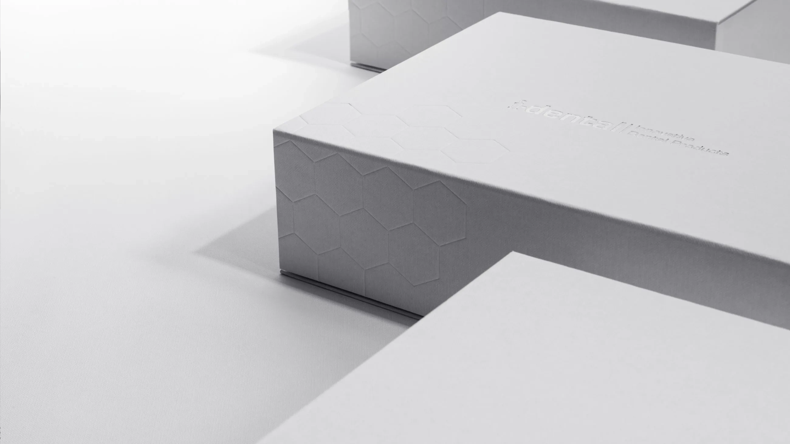 Minimalist white i-dental packaging box by Bigso with embossed hexagon pattern, premium design for innovative dental products.