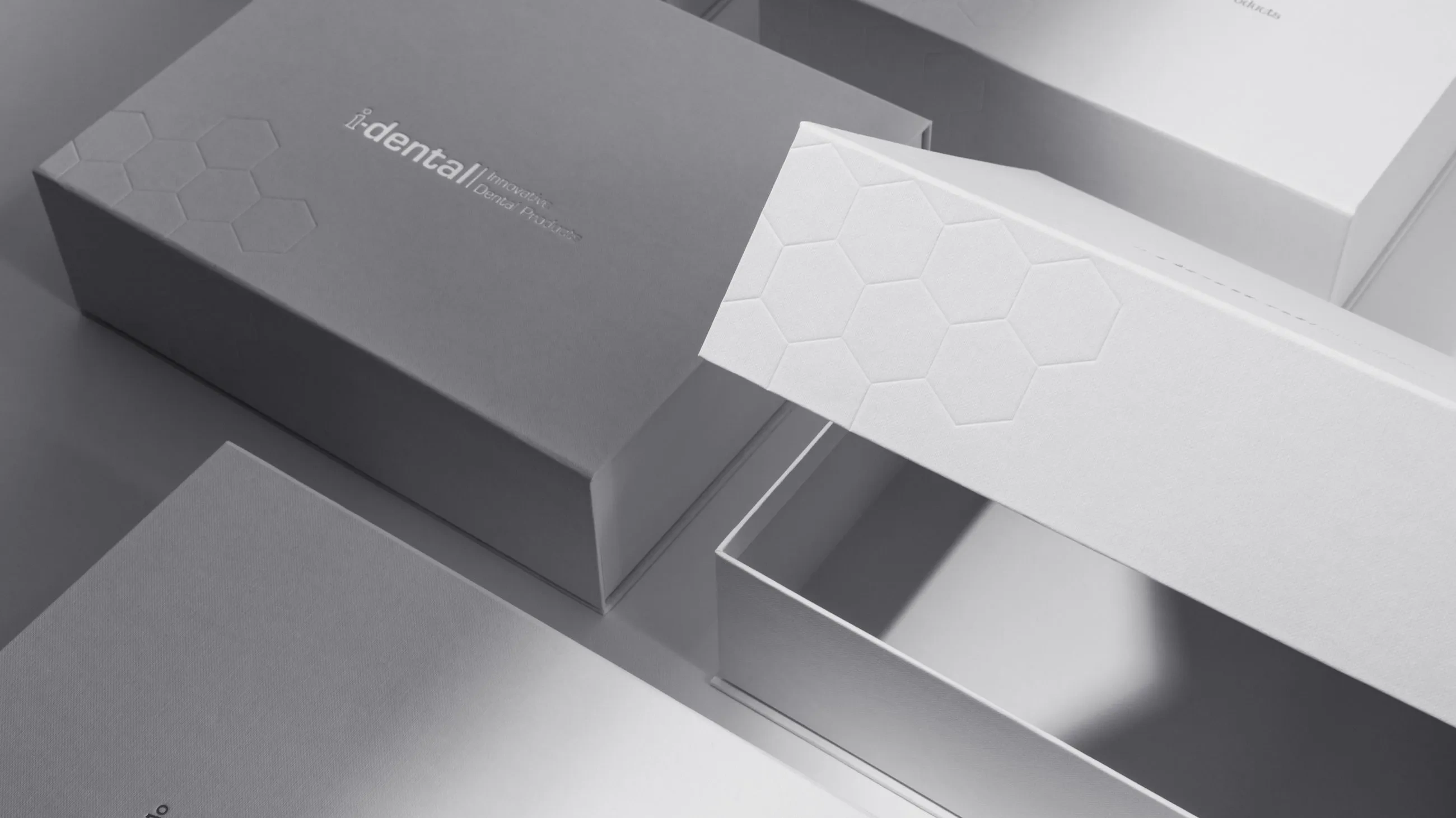 Luxury white i-dental packaging box with embossed hexagon pattern and silver logo, premium design by Bigso for innovative dental products.