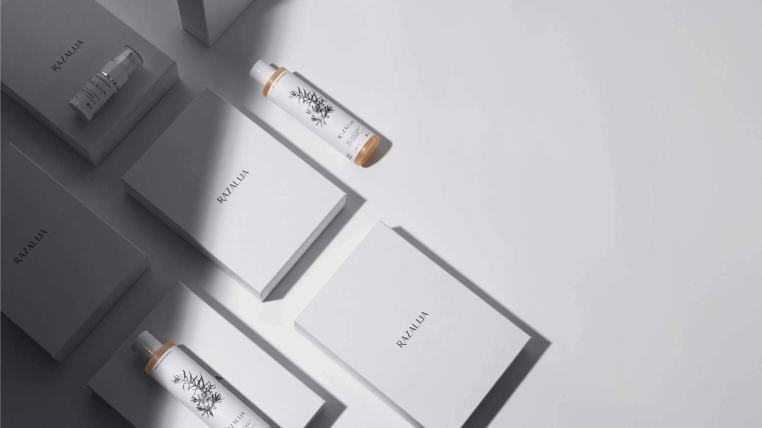 Luxury minimalist packaging for Razalija skincare line, featuring white rigid boxes and sleek botanical-illustrated bottles, produced by Bigso.