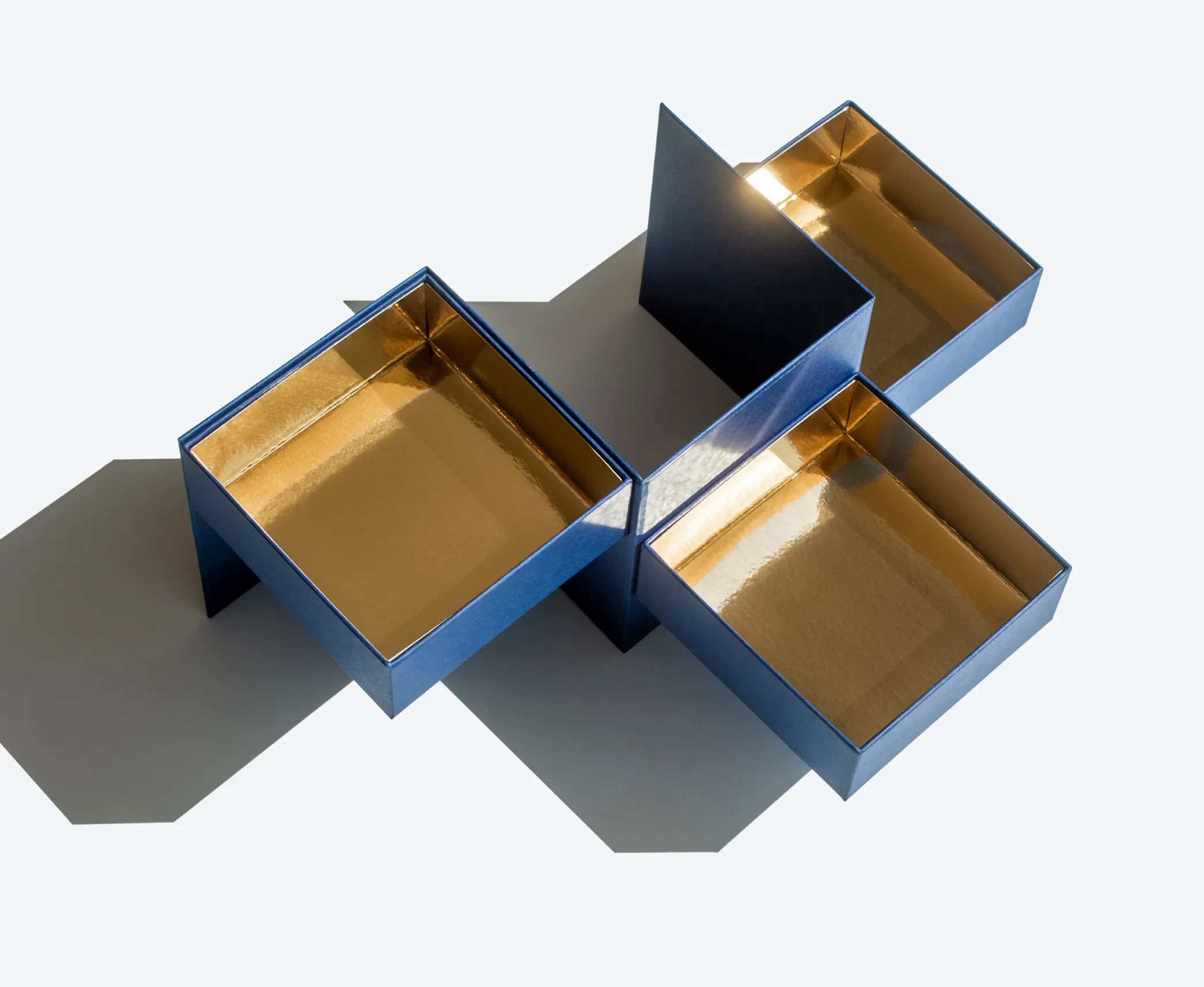 Blue transformer rigid box with gold interior, unfolded into four separate compartments.