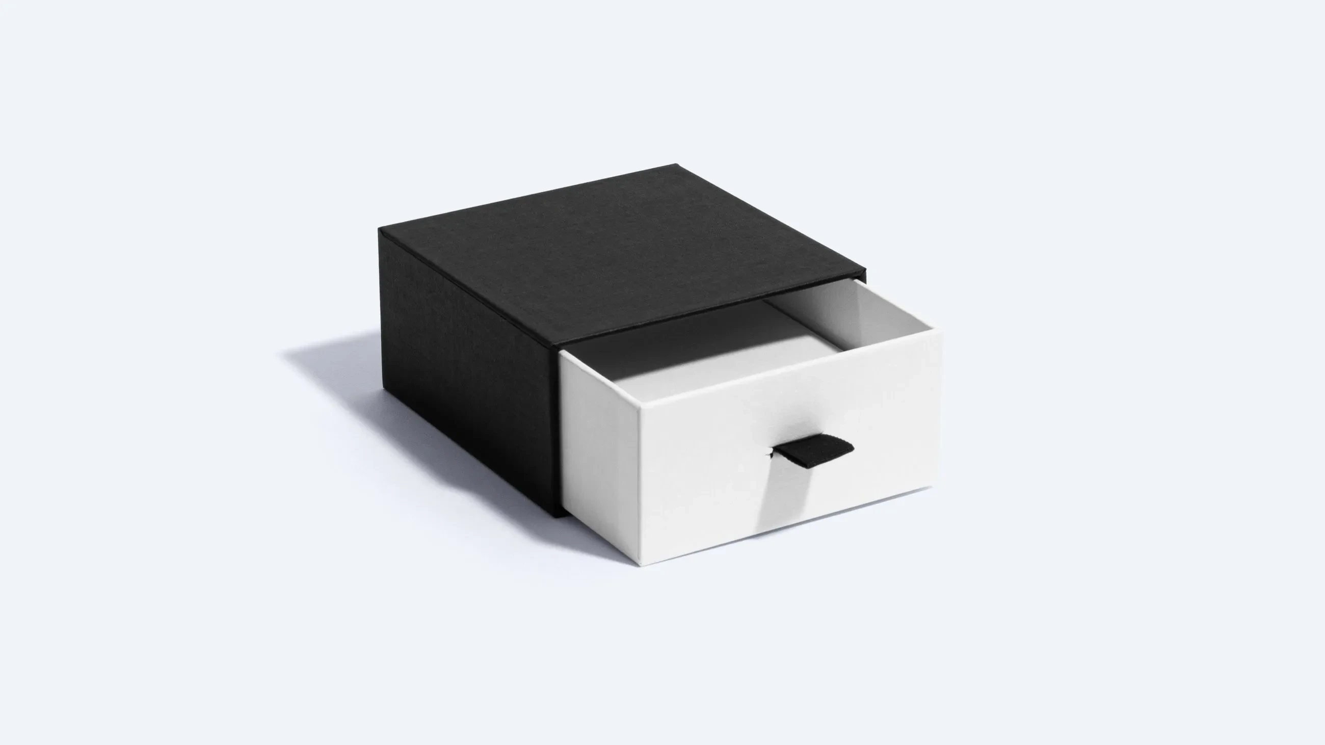 A black and white rigid drawer box with the inner tray partially pulled out, showing its storage space.