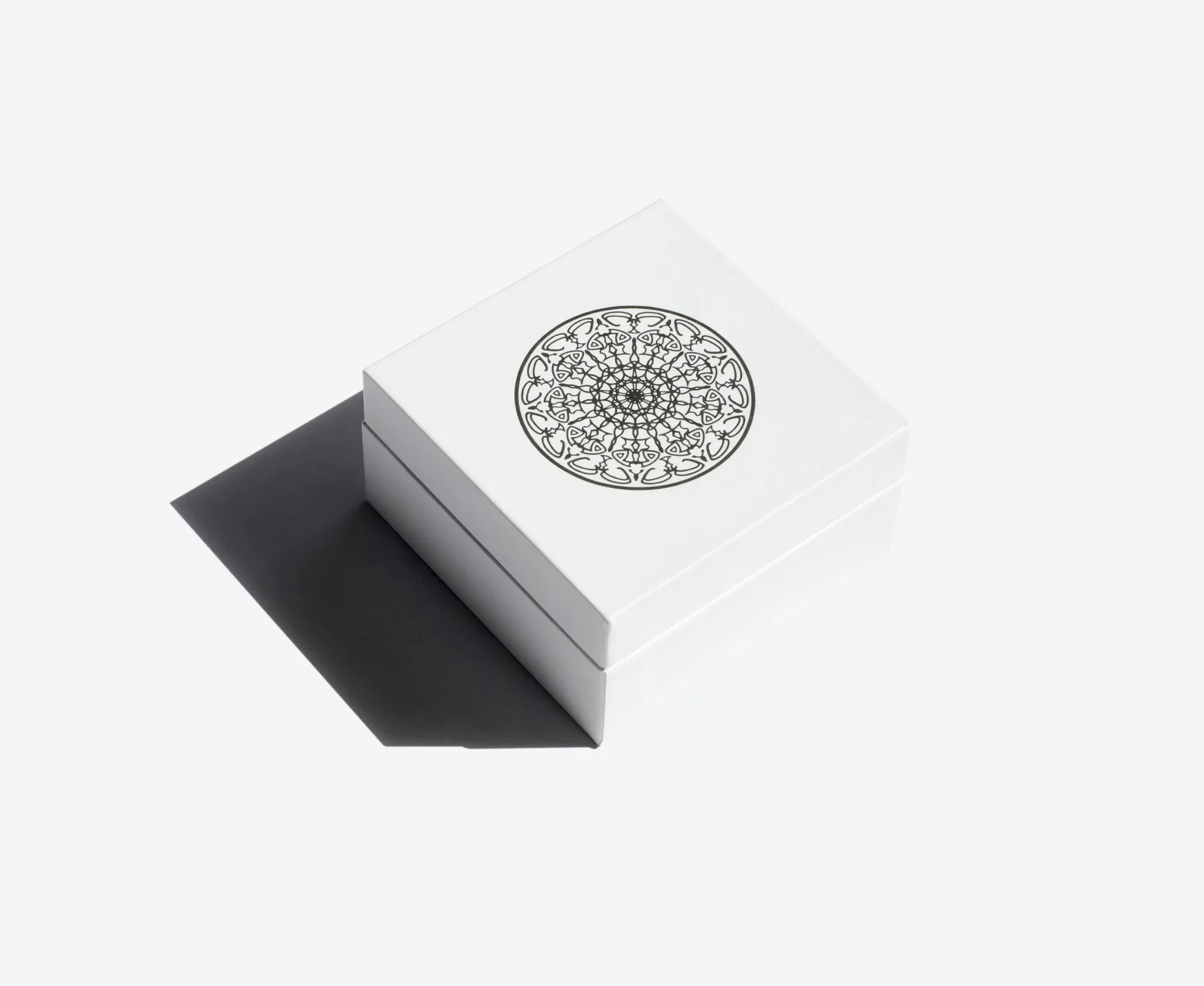 White square hinged lid box with a black mandala design printed on the top.
