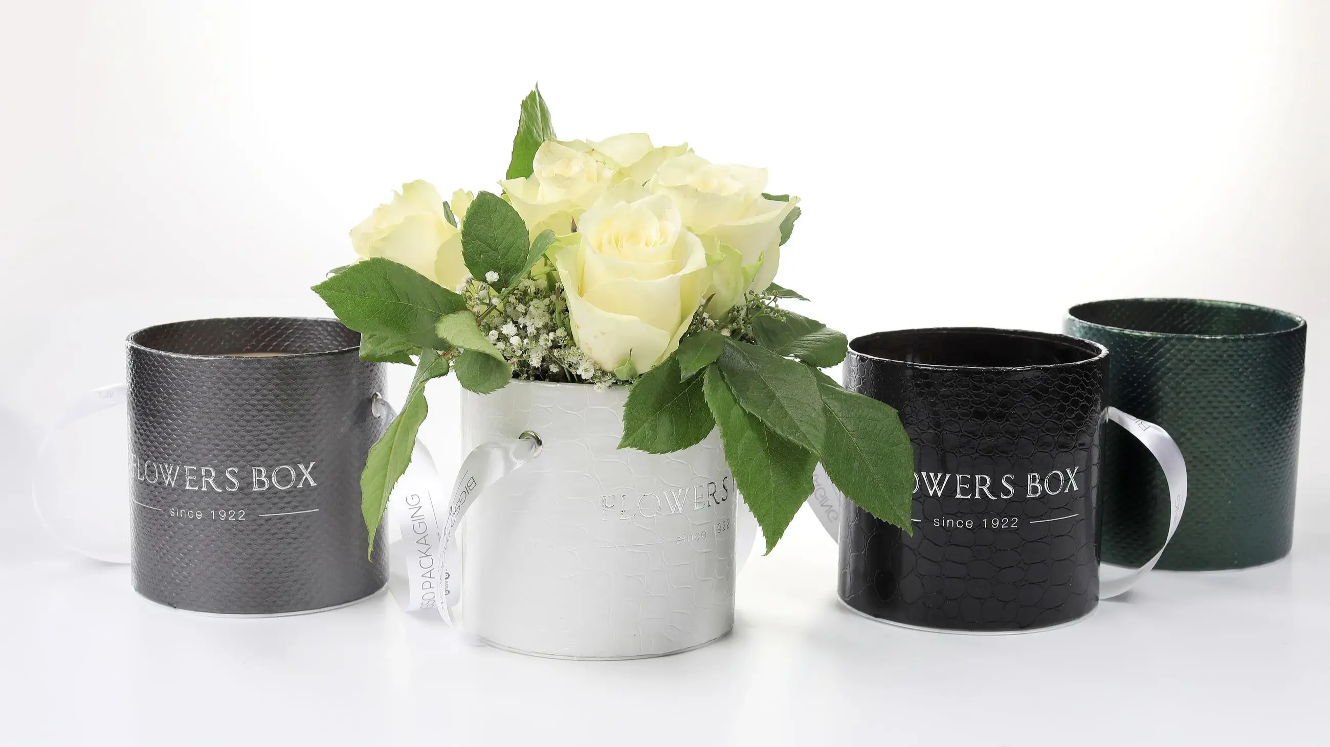 Flower Round Box with Handle – Decorative round rigid box in multiple finishes (black, white, green) with handles, designed for flower arrangements or luxury gifts.