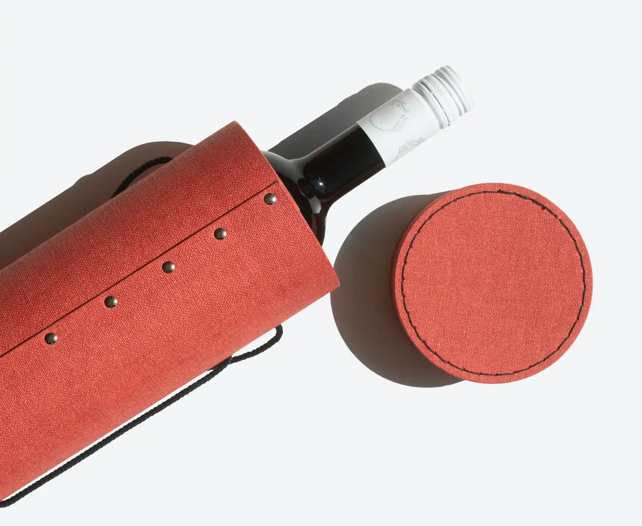Round Box for Wine Packaging – Elegant red cylindrical rigid box with stitched details and rivets, designed to securely hold and present a wine bottle.