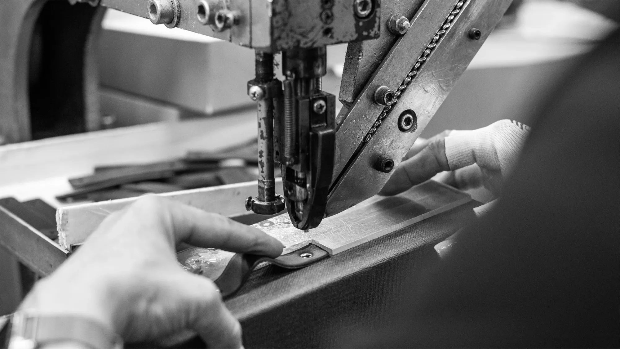 Bigso sustainability – craftsman sewing eco-friendly packaging box with riveted handle for durable handmade design.