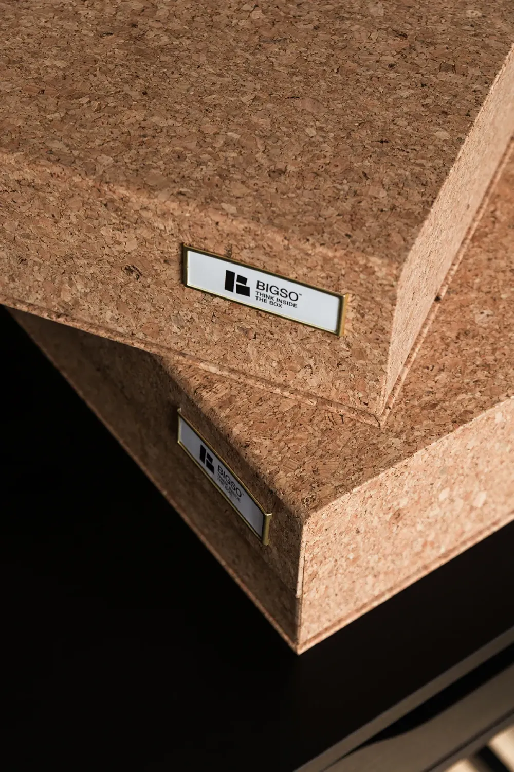 Close-up of Bigso cork-covered storage boxes with metal label holders, showcasing natural textures and eco-friendly materials. These sustainable storage solutions combine Scandinavian design with durability, ideal for home organization and stylish office storage.