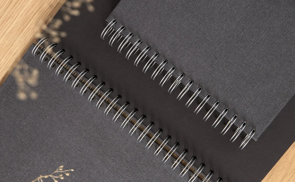 Close-up of eco-friendly spiral-bound notebooks with grey recycled canvas covers. The textured canvas material adds durability and a premium feel, while emphasizing Bigso’s commitment to sustainable materials and timeless Scandinavian design for everyday stationery and office organization.