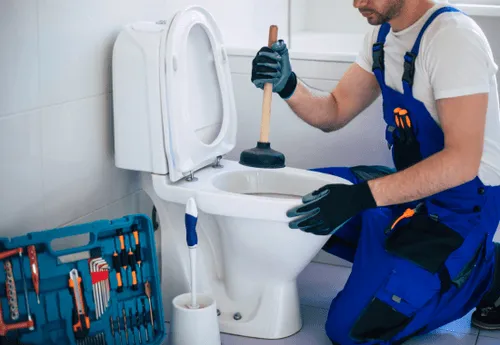 Rohrexperte Bremen bei der Rohrreinigung einer verstopften Toilette mit professionellem Werkzeug.