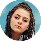 Young woman with braided hair and a neutral expression against a blue background.