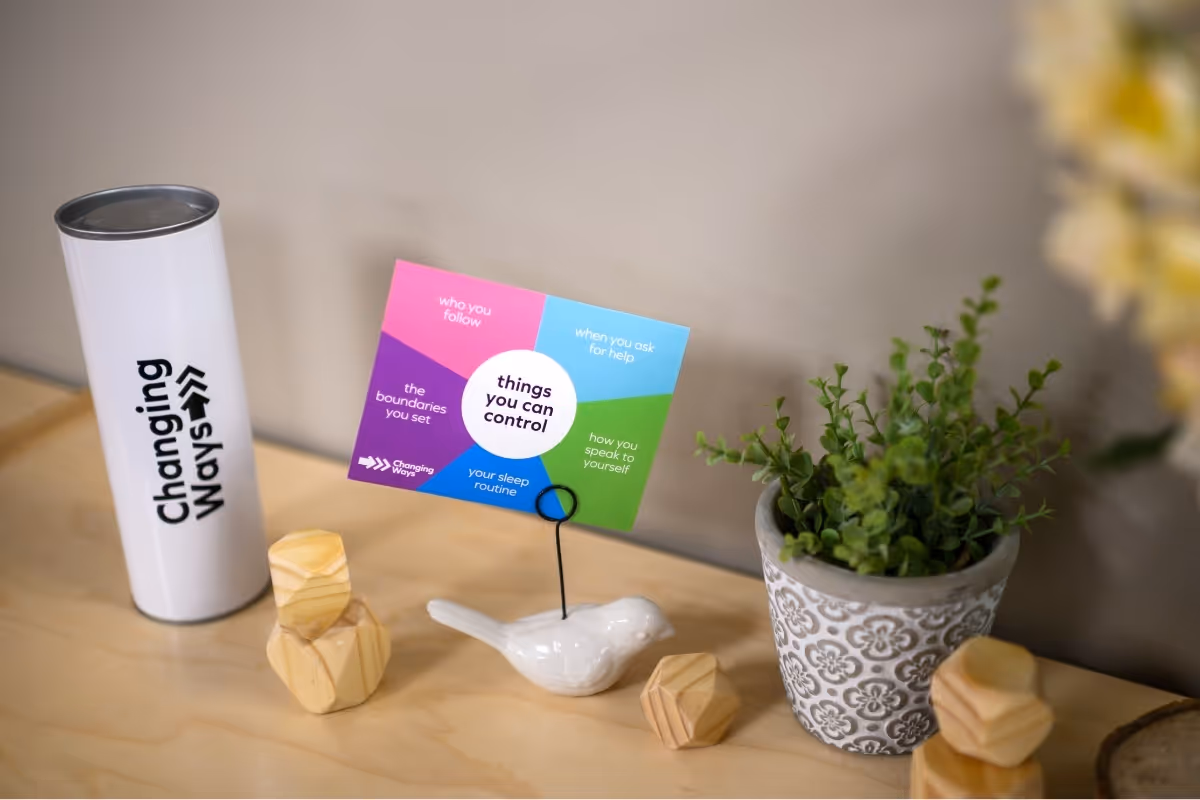 desktop with plants, cup, and card that says 'things you can control'