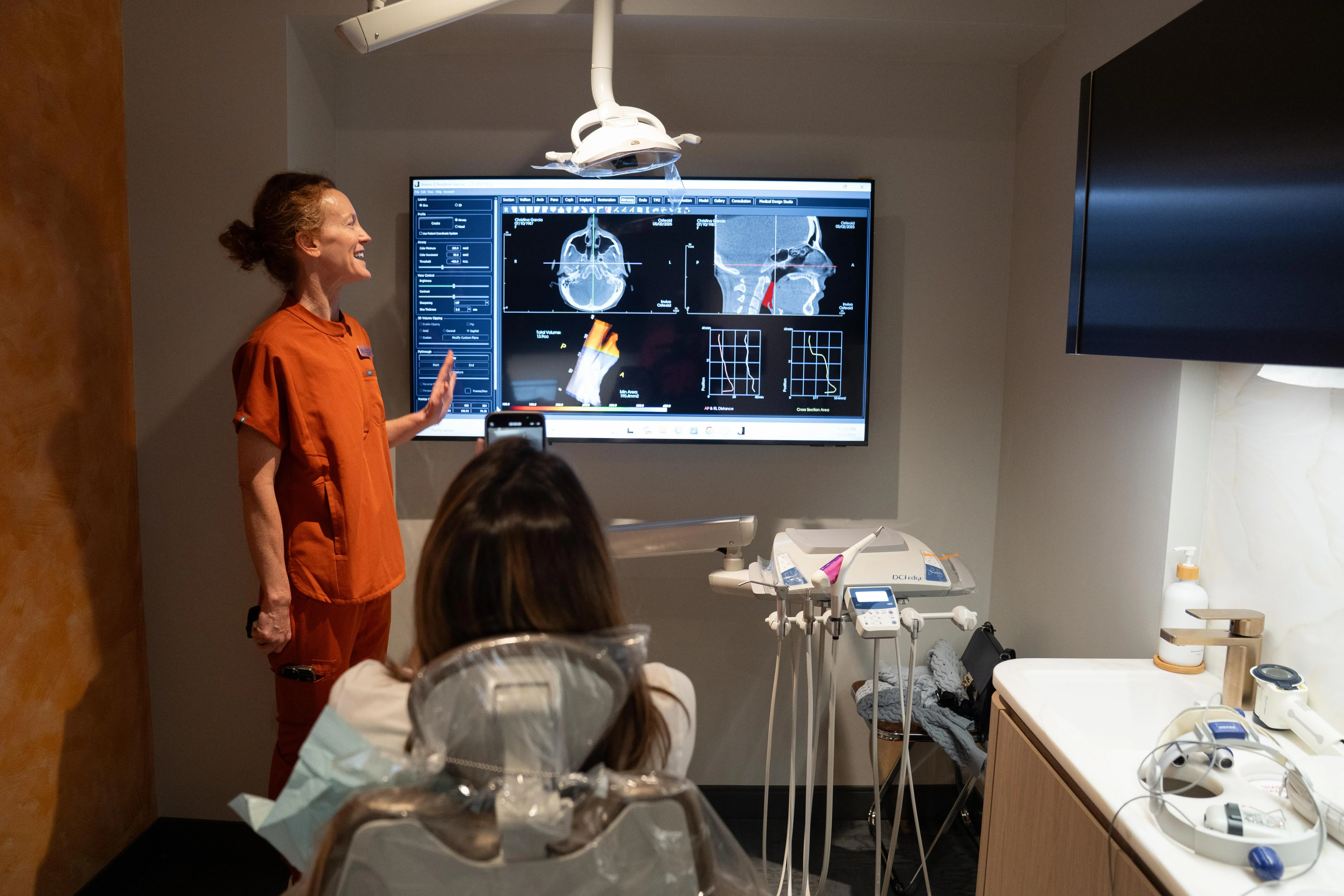 Smile House clinician walking a patient through a Mouth Mapping scan on a large screen